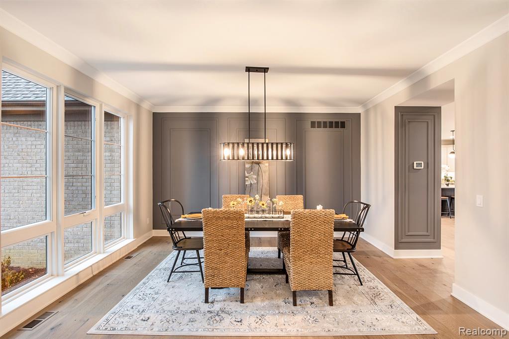 Dining space featuring crown molding and light wood-type flooring