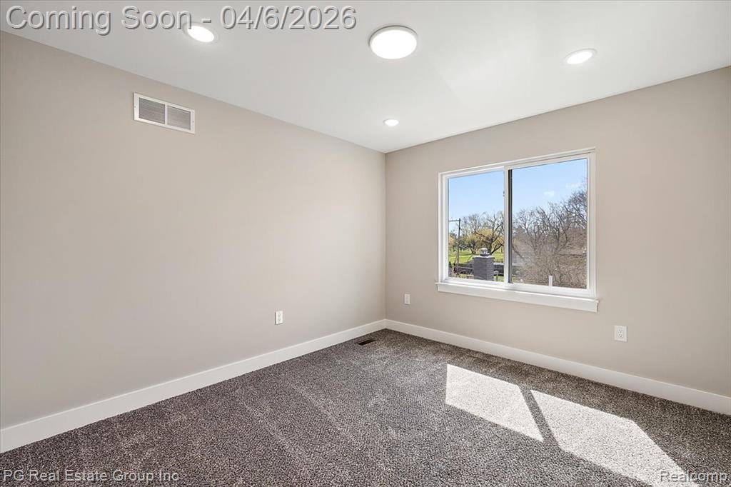 Carpeted spare room featuring baseboards and recessed lighting