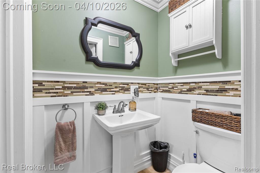 Bathroom featuring toilet and crown molding