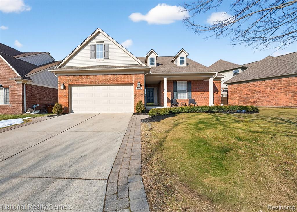 Photo for 6871 Haymarket, Utica, MI 48317 - Listing #20261010773 View of front of property featuring brick siding, a front lawn, driveway, and covered porch