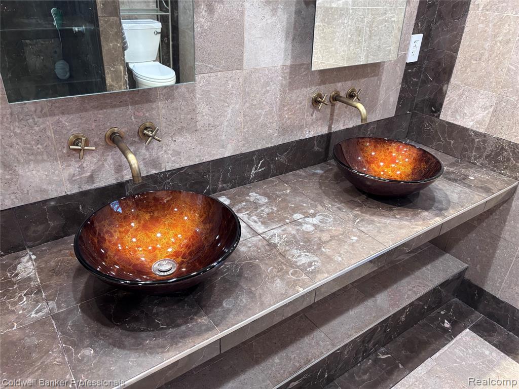 Bathroom view of tile walls, tasteful backsplash, and vanity