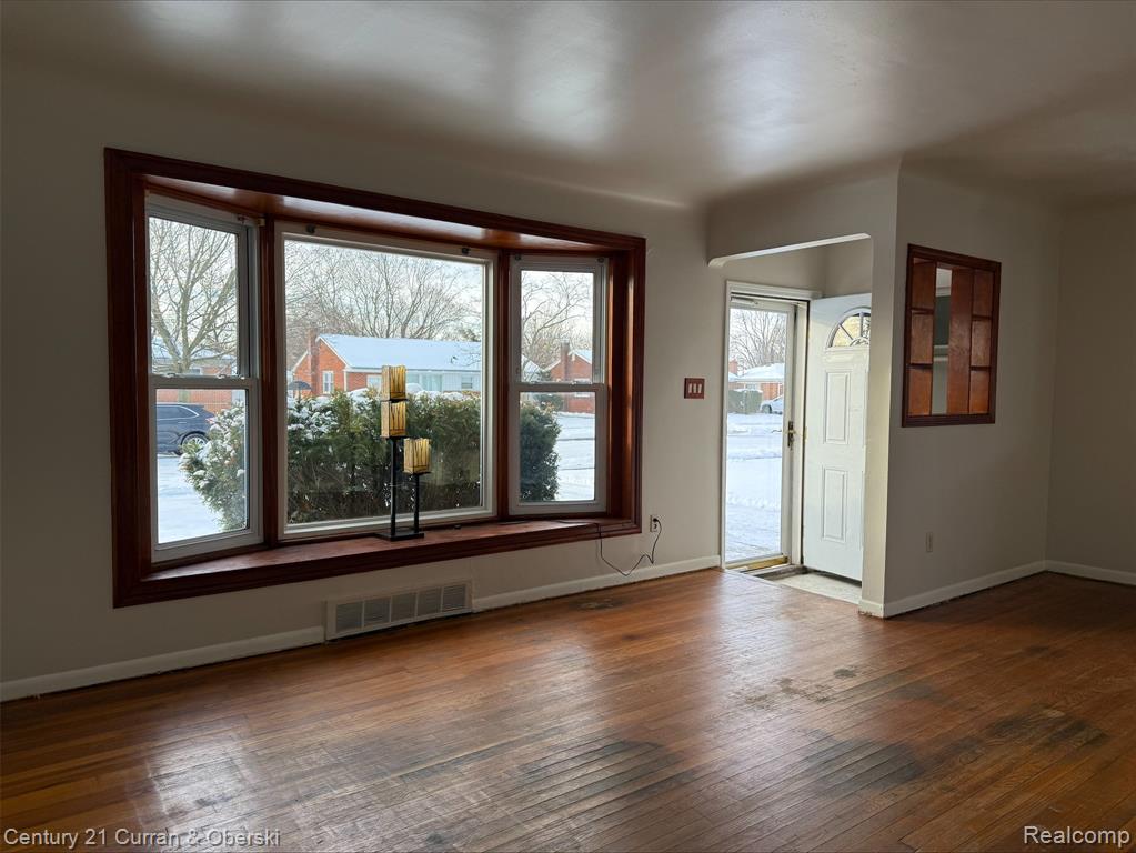 Spare room with wood-type flooring and baseboards