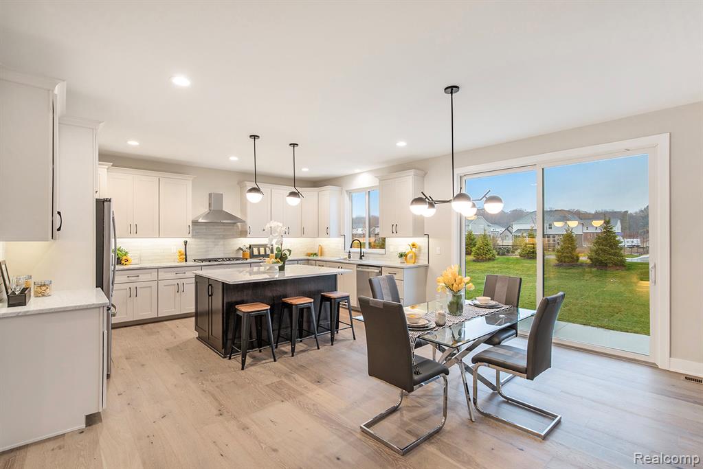 Dining room with light wood-type flooring and recessed lighting