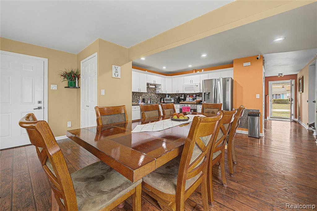 Dining room with dark wood finished floors and recessed lighting