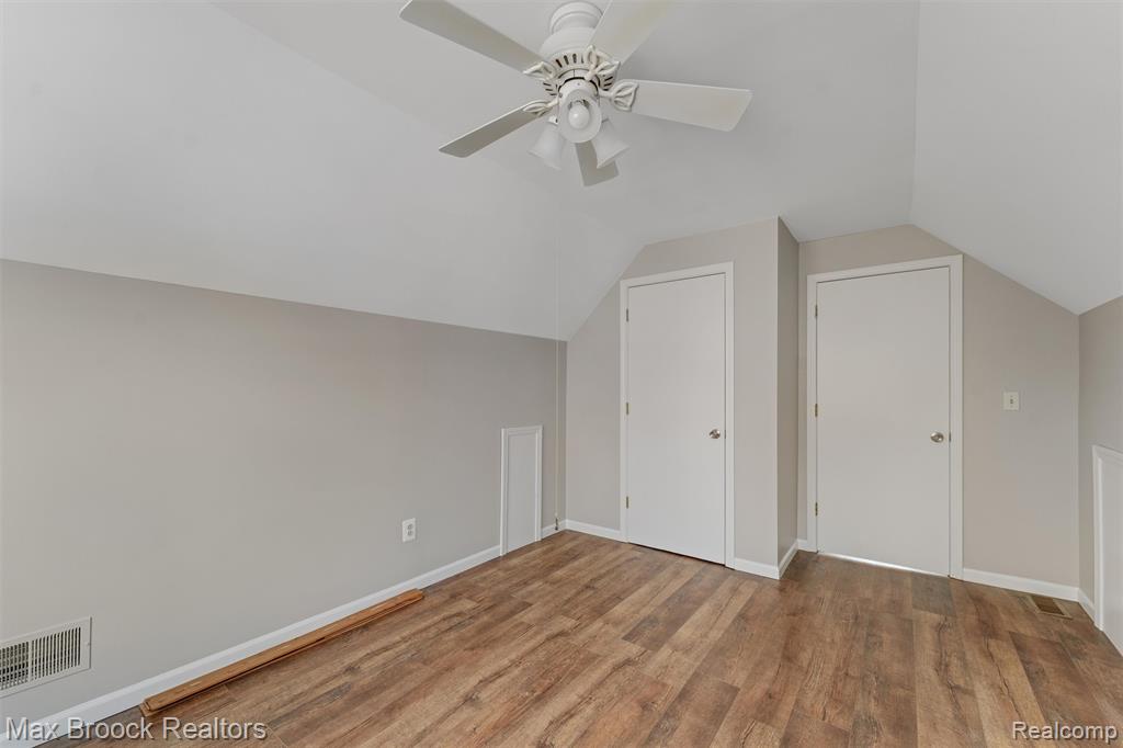 Additional living space with a ceiling fan, vaulted ceiling, and light wood-type flooring