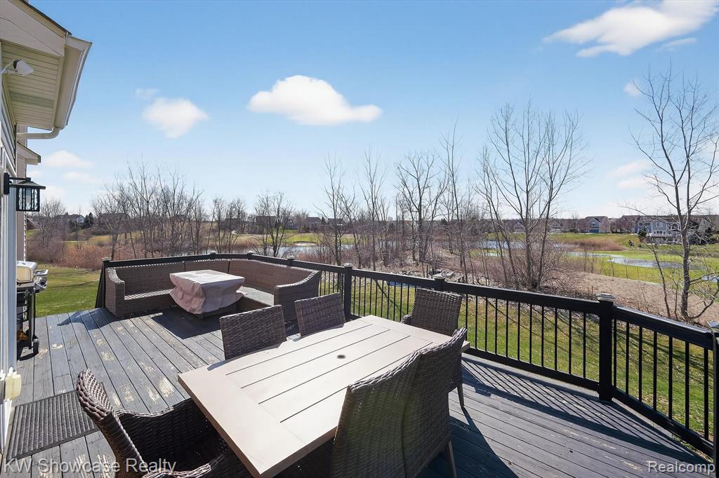 Deck with outdoor dining space, a residential view, and a yard