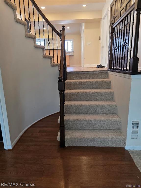 Staircase with wood finished floors and baseboards