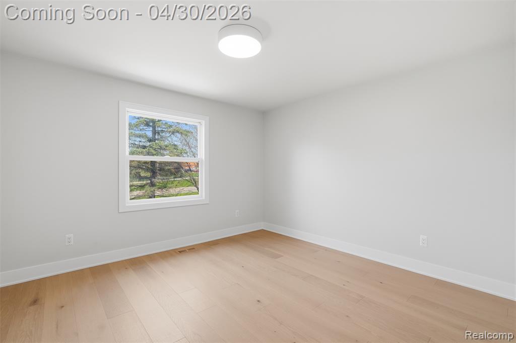 Spare room featuring baseboards and light wood finished floors