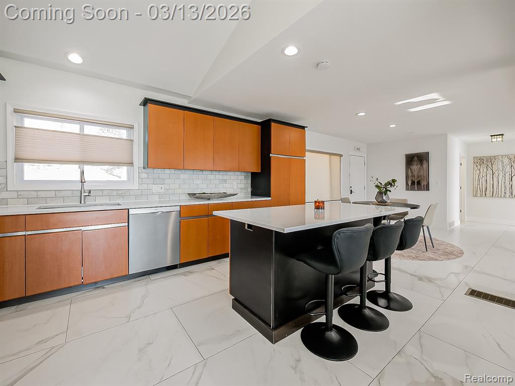 Kitchen featuring stainless steel appliances, ceiling fan, light marble finish floors, tasteful backsplash, and light stone countertops