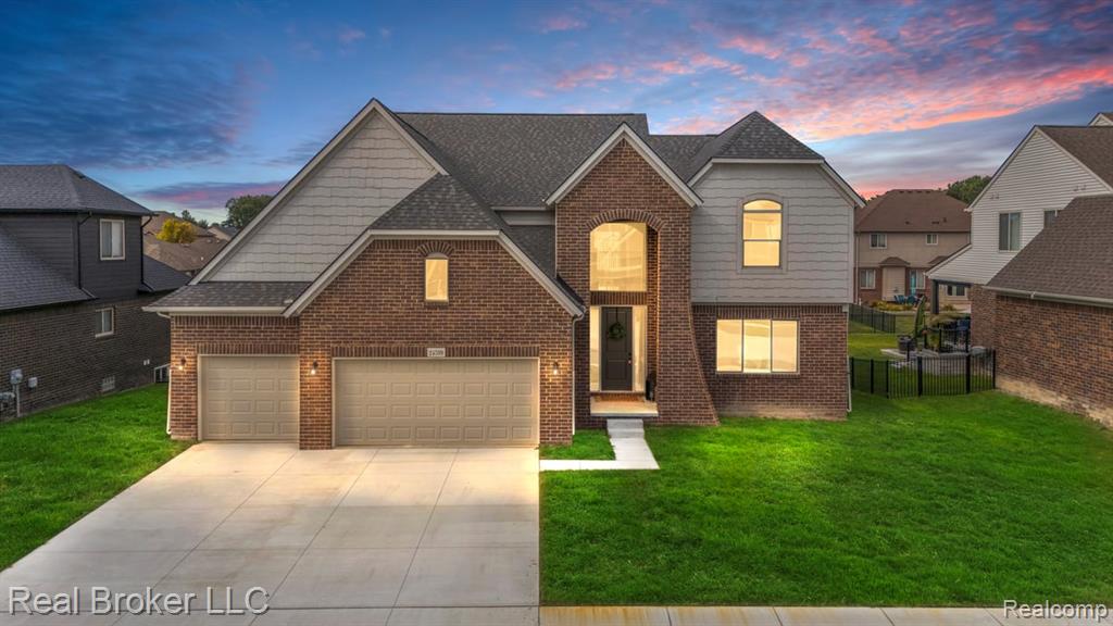 View of front of property featuring brick siding, roof with shingles, and concrete driveway