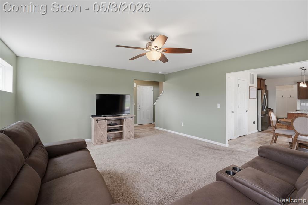 Living room featuring ceiling fan and light colored carpet