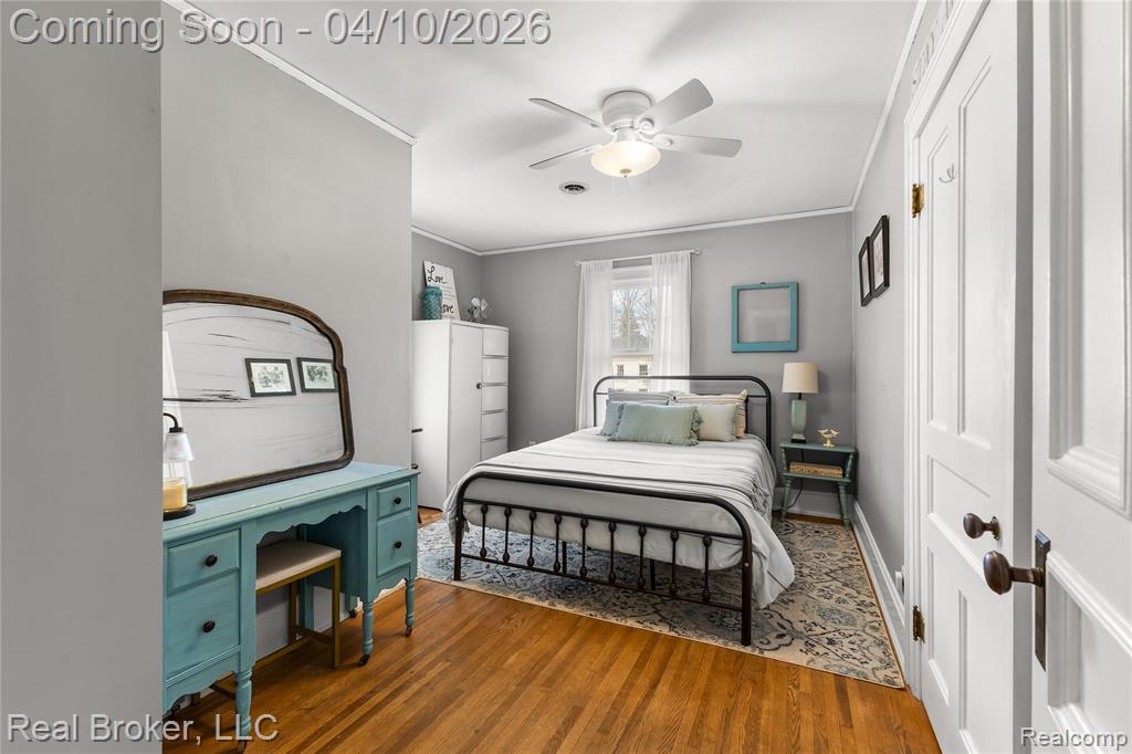 Bedroom with crown molding, ceiling fan, and wood finished floors