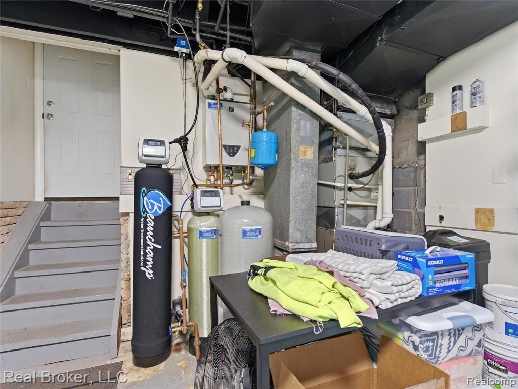 Utility area featuring a water softener system, water heater, and a furnace unit