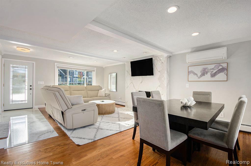 Dining room featuring ornamental molding, a textured ceiling, light wood-style flooring, recessed lighting, and beam ceiling