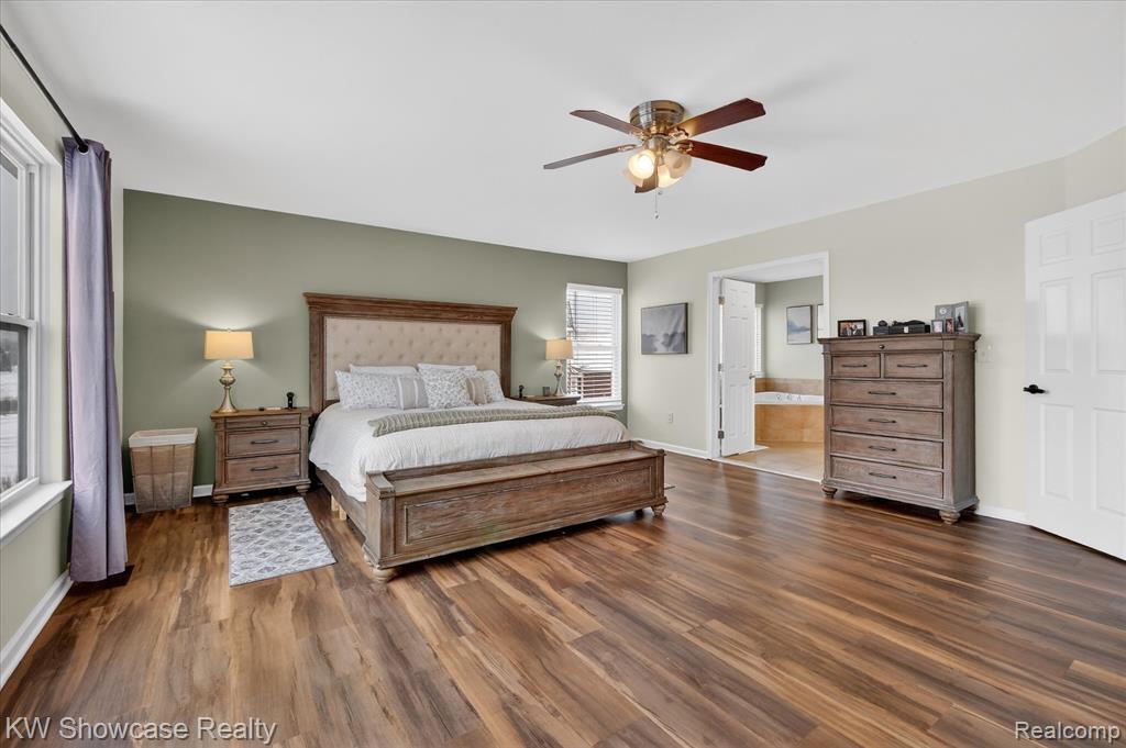 Full bath with double vanity, light tile patterned floors, a stall shower, ensuite bath, and ceiling fan