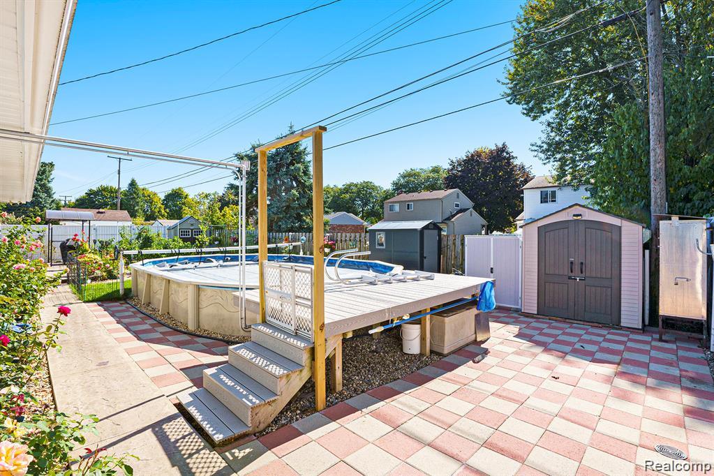 Fenced backyard with a patio and a storage unit