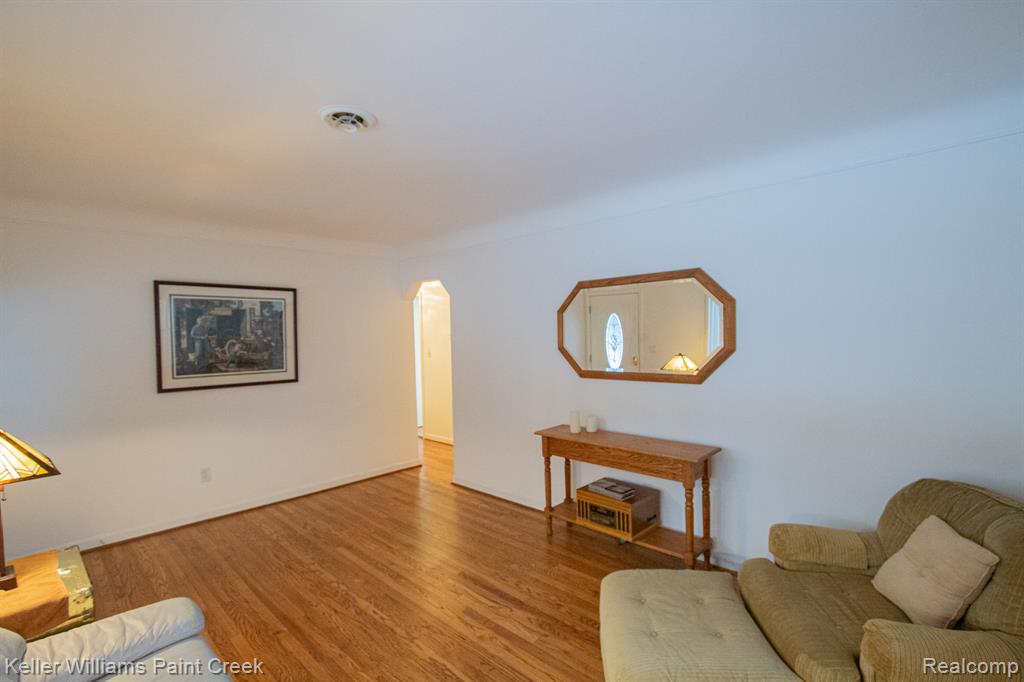 Living area featuring arched walkways and wood finished floors