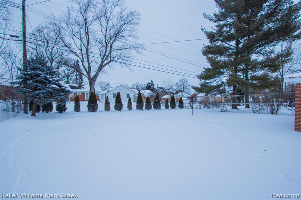 Snowy yard with a residential view