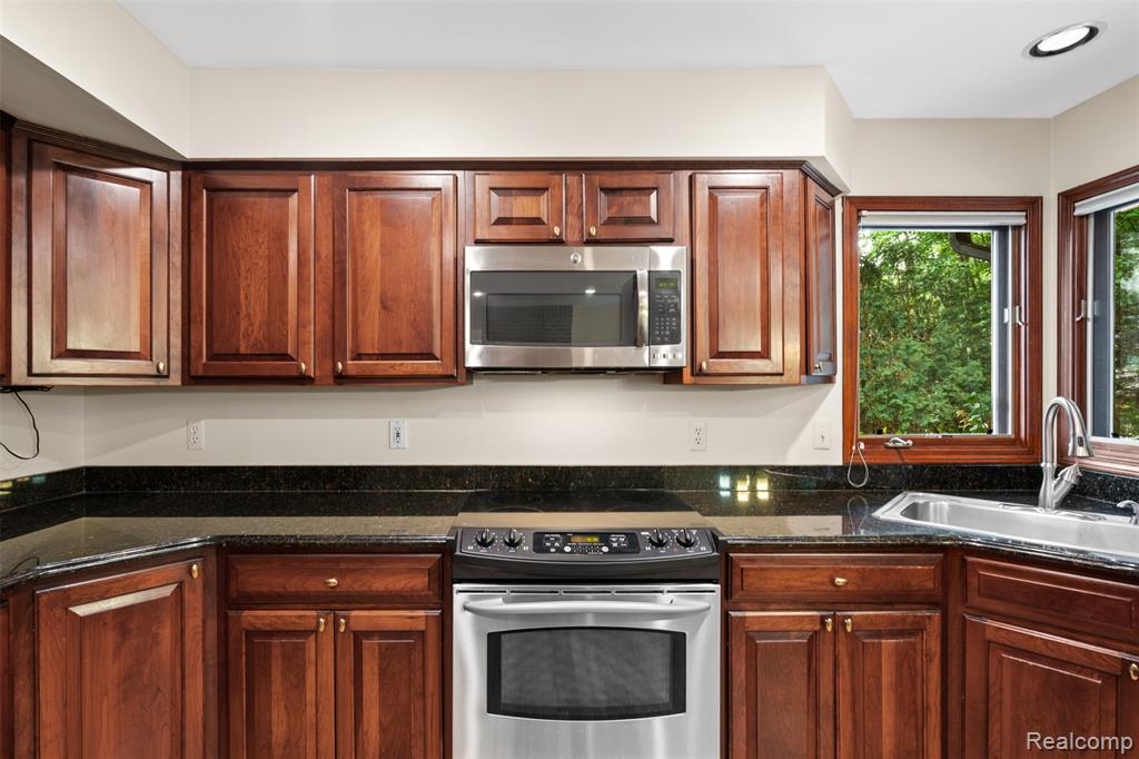Kitchen with stainless steel appliances and dark stone counters