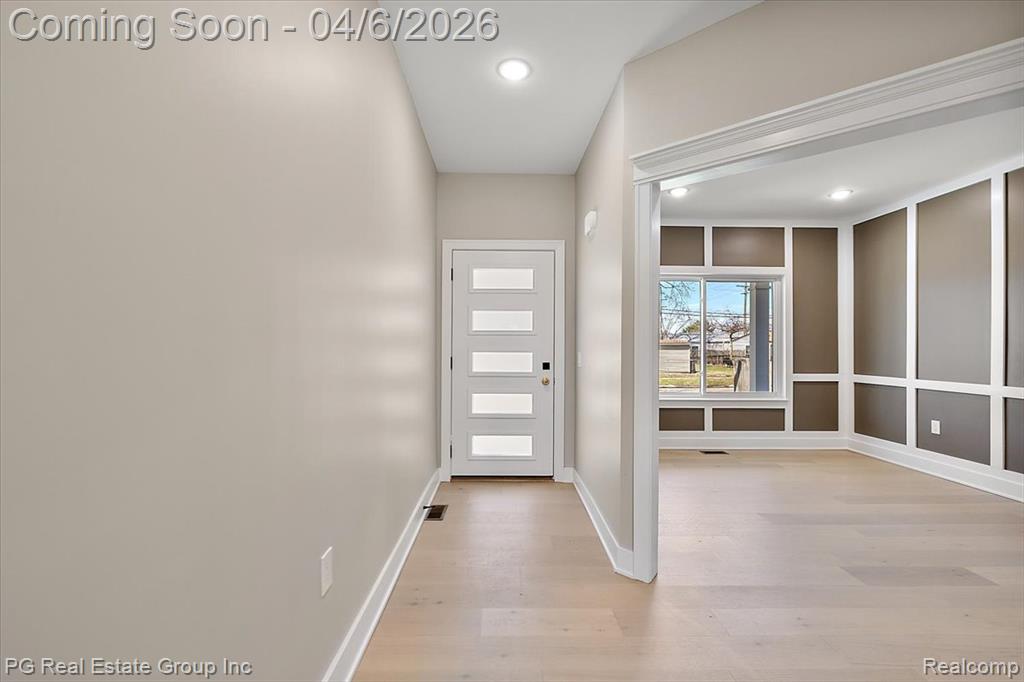 Entryway with wood finished floors and recessed lighting