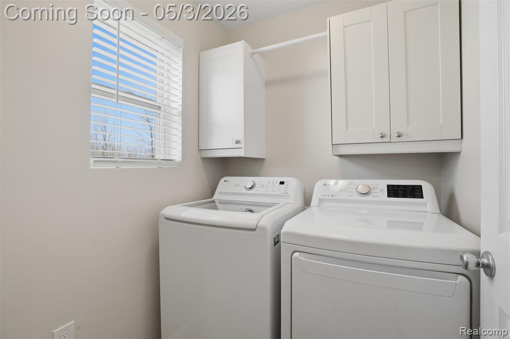 Laundry room with washer and clothes dryer and cabinet space