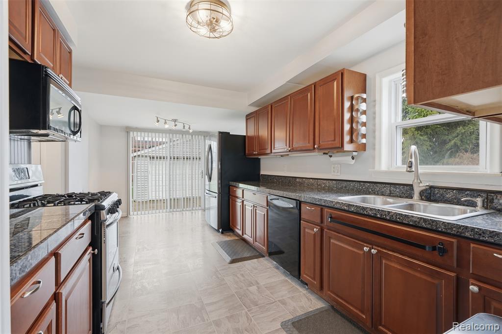 Kitchen with black appliances and wood finish cabinetry