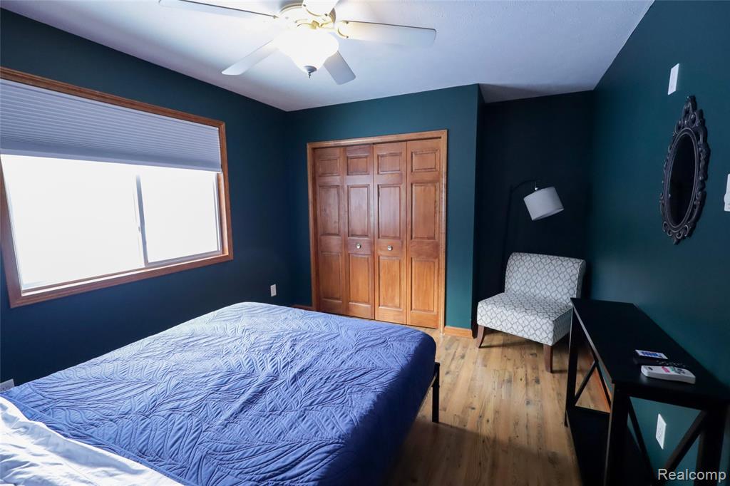 Bedroom featuring wood finished floors, a closet, and ceiling fan