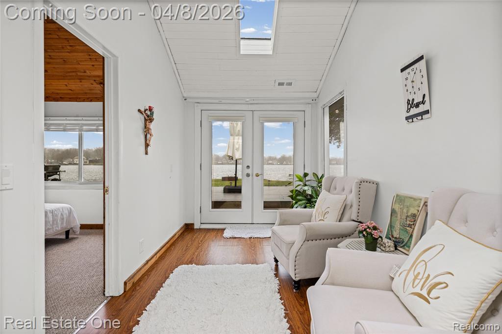 Sitting room featuring a vaulted wood ceiling, french doors, and wood finished floors