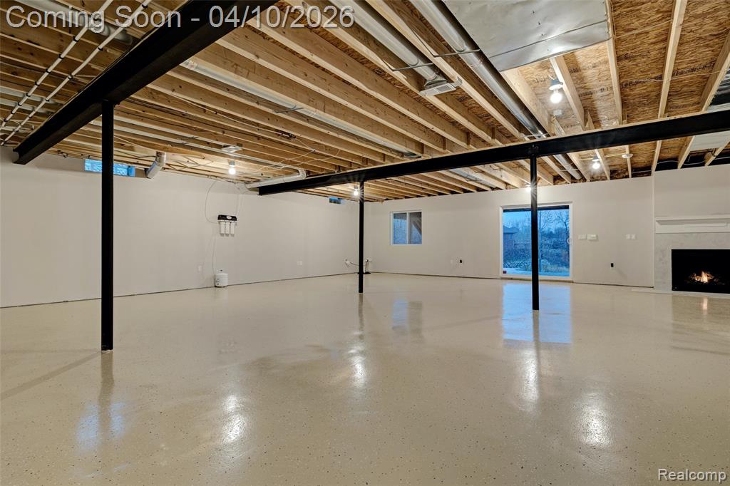 Below grade area with a lit fireplace