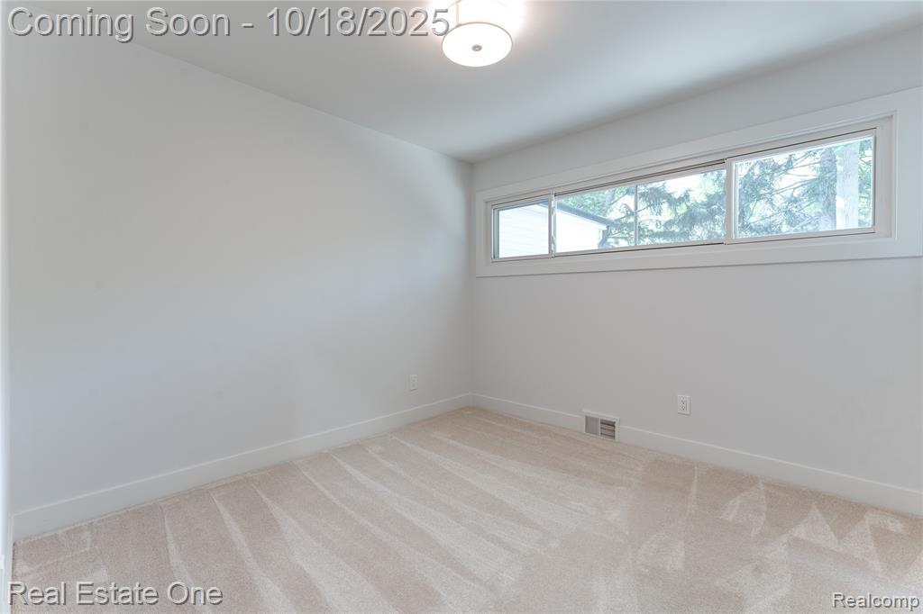 Unfurnished room with light carpet and baseboards