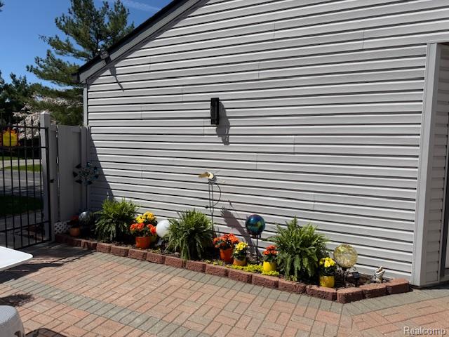 View of side of home featuring a gate