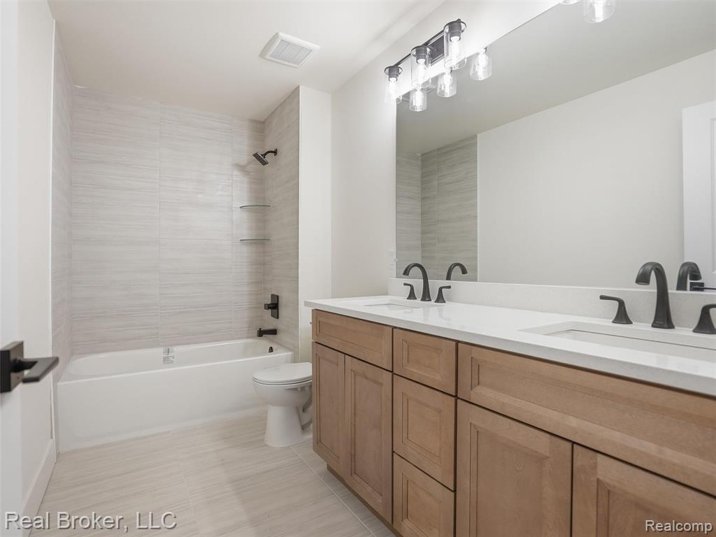 Bathroom featuring double vanity and shower / bathtub combination
