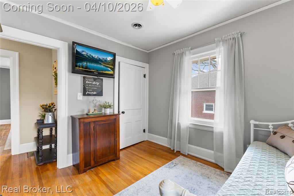 Bedroom featuring crown molding and light wood-type flooring