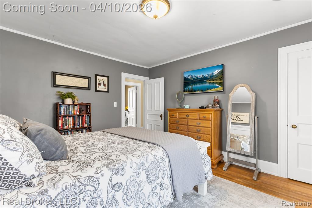 Bedroom featuring crown molding and light wood-style floors
