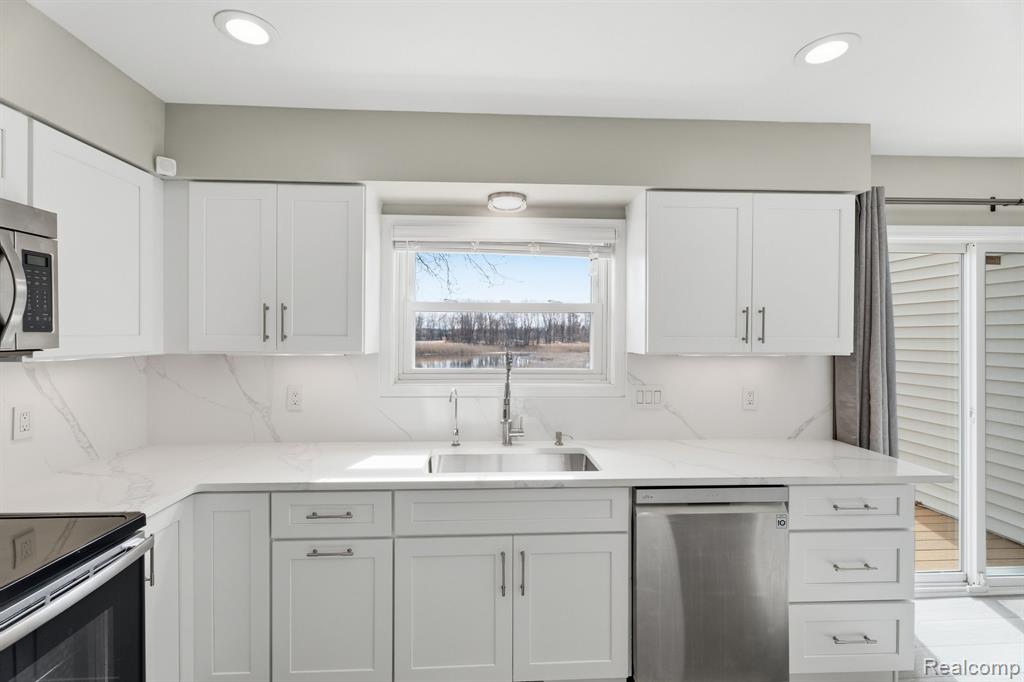 Kitchen featuring stainless steel appliances, white cabinets, and recessed lighting