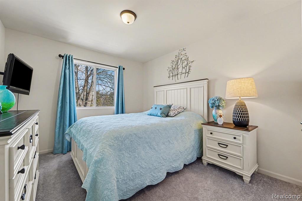 Bedroom featuring baseboards and dark carpet