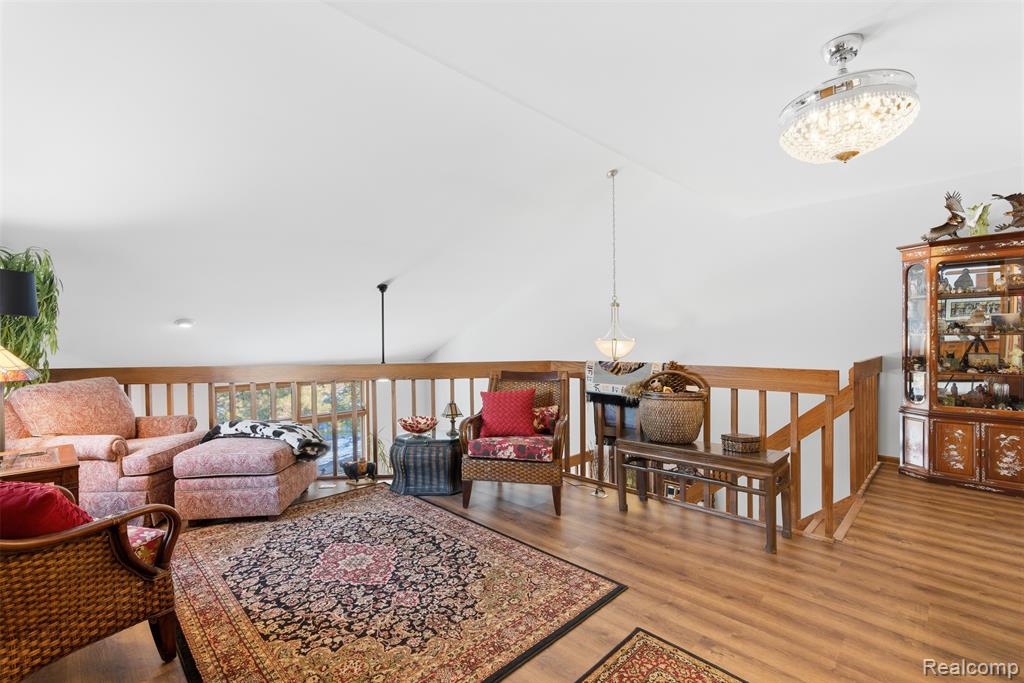Living room featuring light wood-style flooring and vaulted ceiling