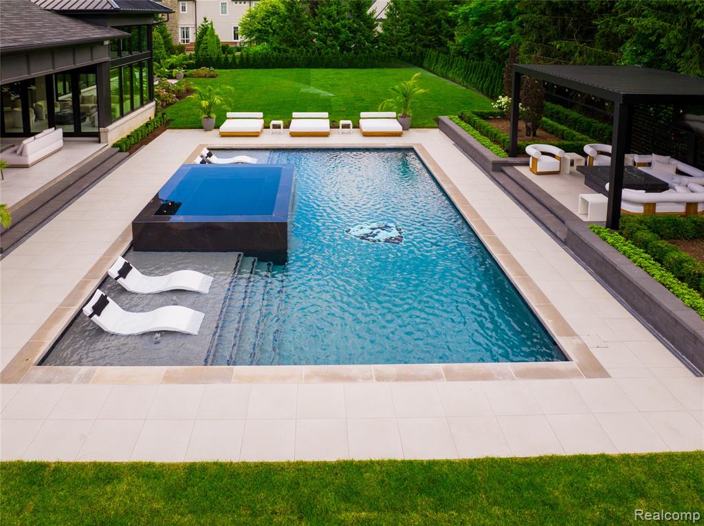 View of pool featuring a patio, a sunroom, and a pool with connected hot tub