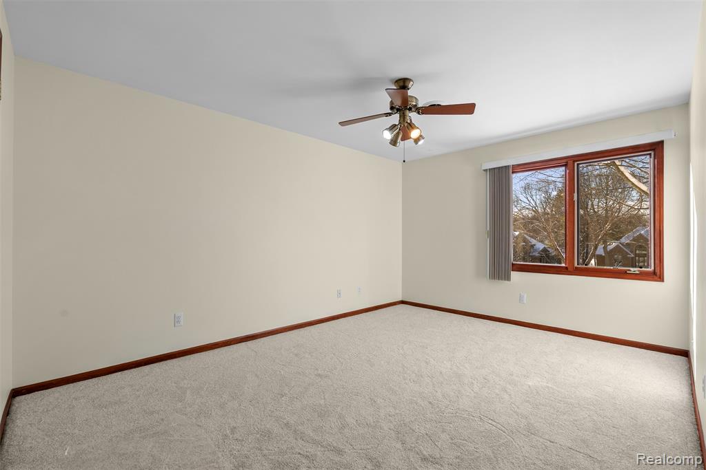 Empty room featuring carpet floors and ceiling fan
