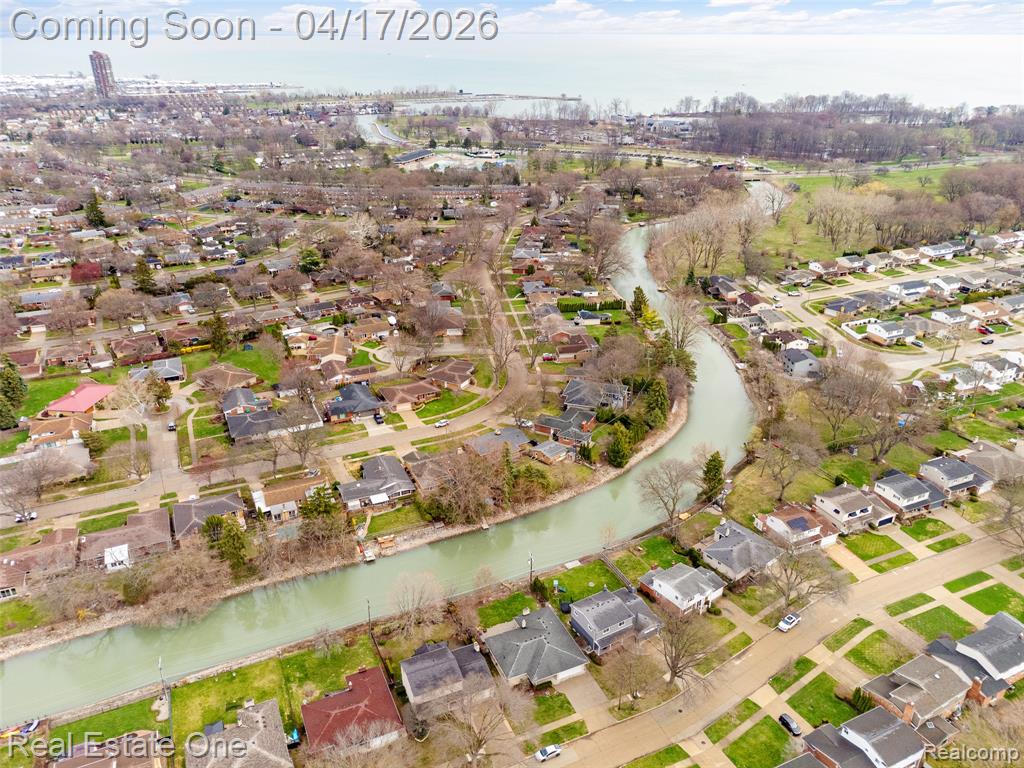 Aerial overview of property's location featuring a nearby body of water and nearby suburban area