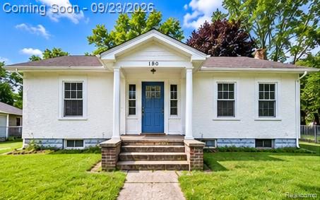 White stucco exterior with a blue front door, covered front porch, and brick steps