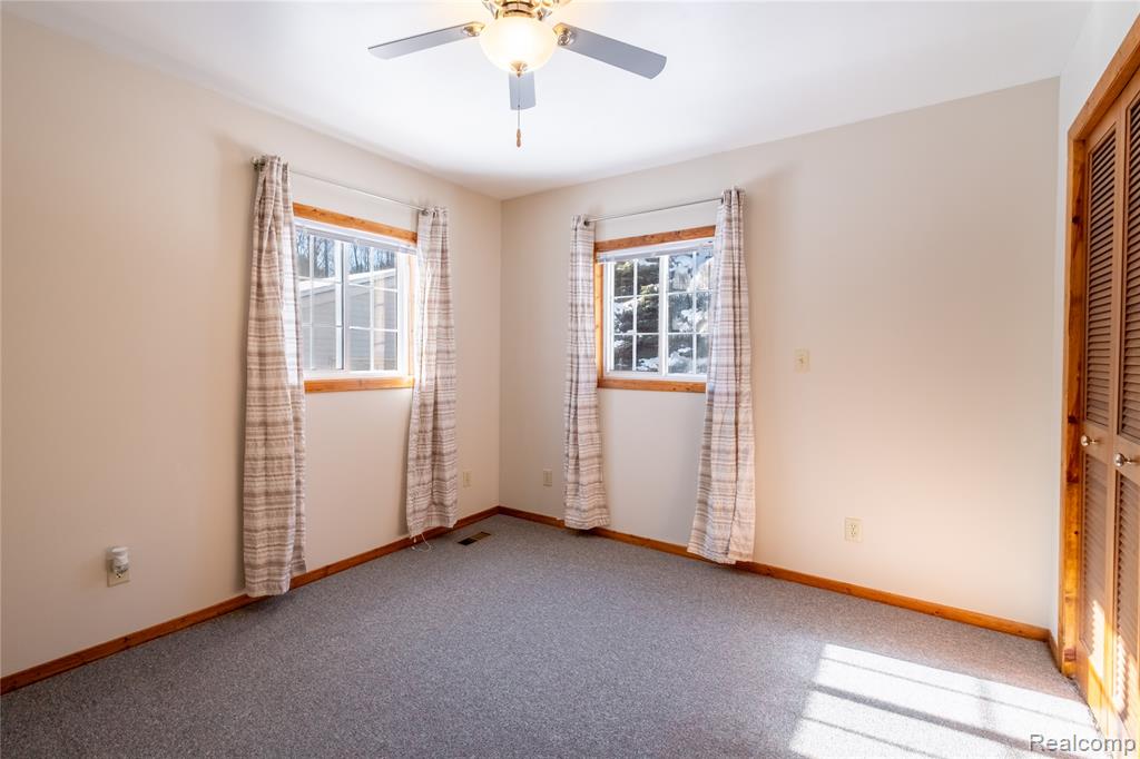 Unfurnished bedroom with a closet, carpet, and ceiling fan