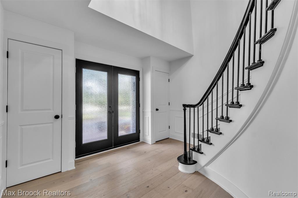 Foyer with french doors and light wood-style floors