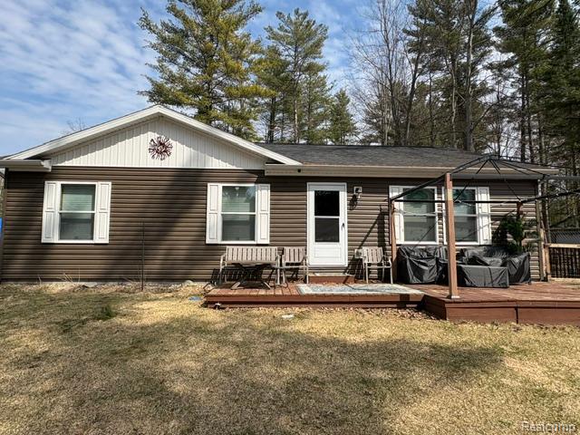 View of front of home featuring a front lawn and a deck