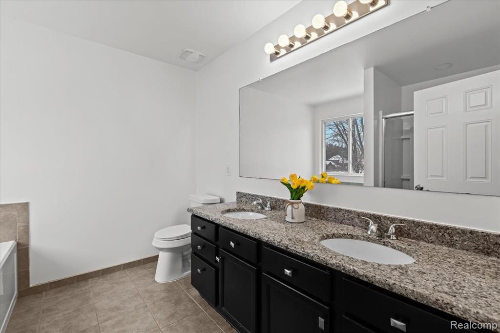 Snow covered house featuring brick siding and a garage