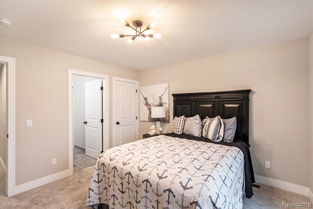 Bedroom with light carpet and a chandelier