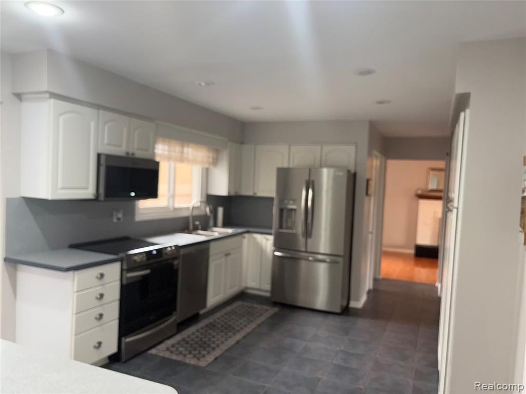 Kitchen with stainless steel appliances and white cabinets