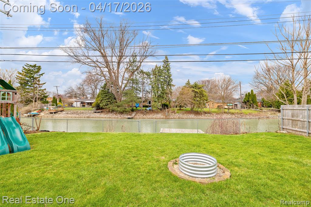 View of yard with a playground and a water view