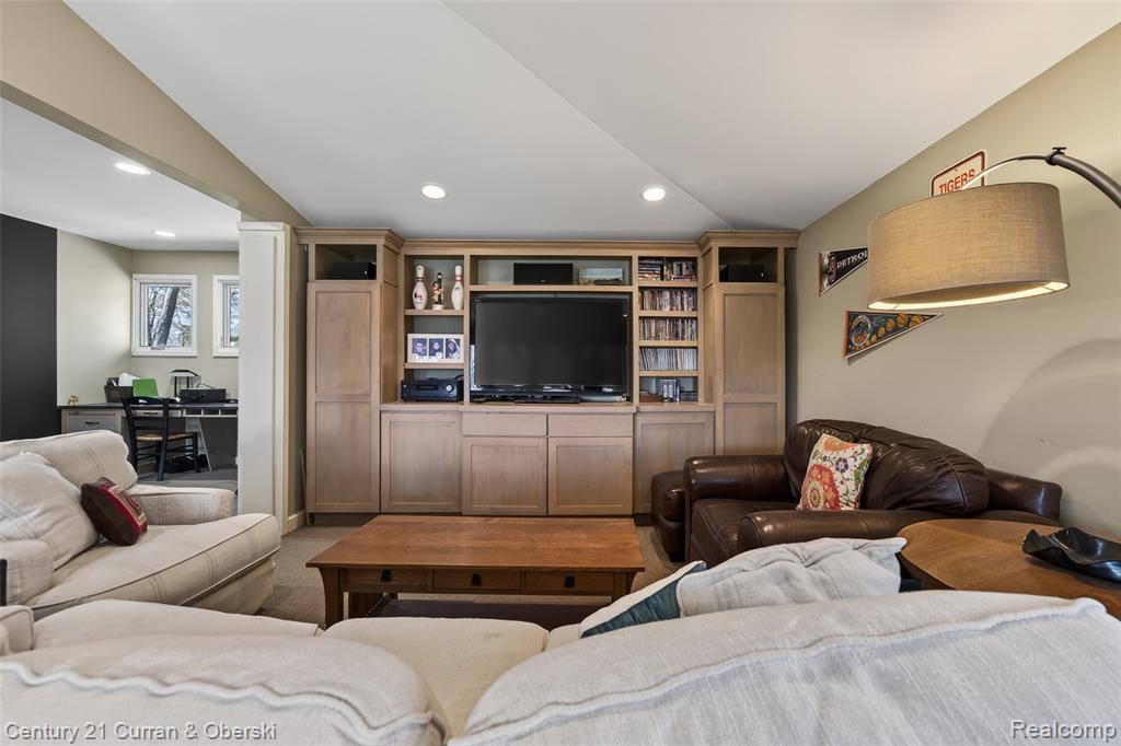 Carpeted living area featuring recessed lighting and lofted ceiling