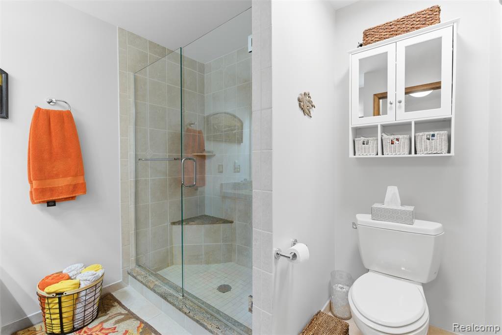 Full bathroom featuring toilet and a shower stall